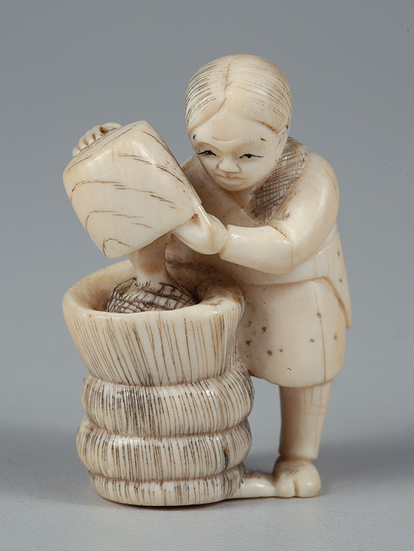 NETSUKE - Em marfim representando preparo do Moti - medindo 5 cm de altura. - Japão - Séc.XX.