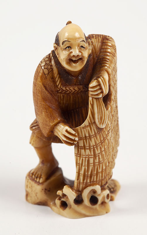 NETSUKE - Representando figura com manto aberto na mão em marfim assinada. - Japão - Séc.XIX ` 5 cm.