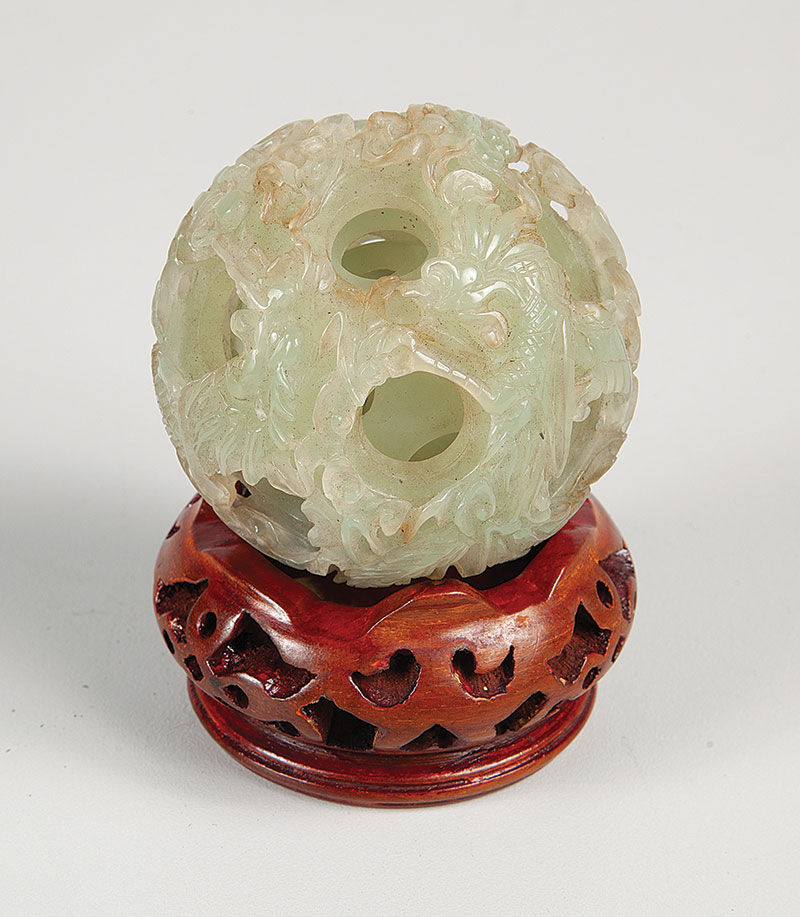 Esfera delicadamente esculpida em jade. - Base em madeira medindo 7 cm de diâmetro. - China ` Séc. XIX-XX.