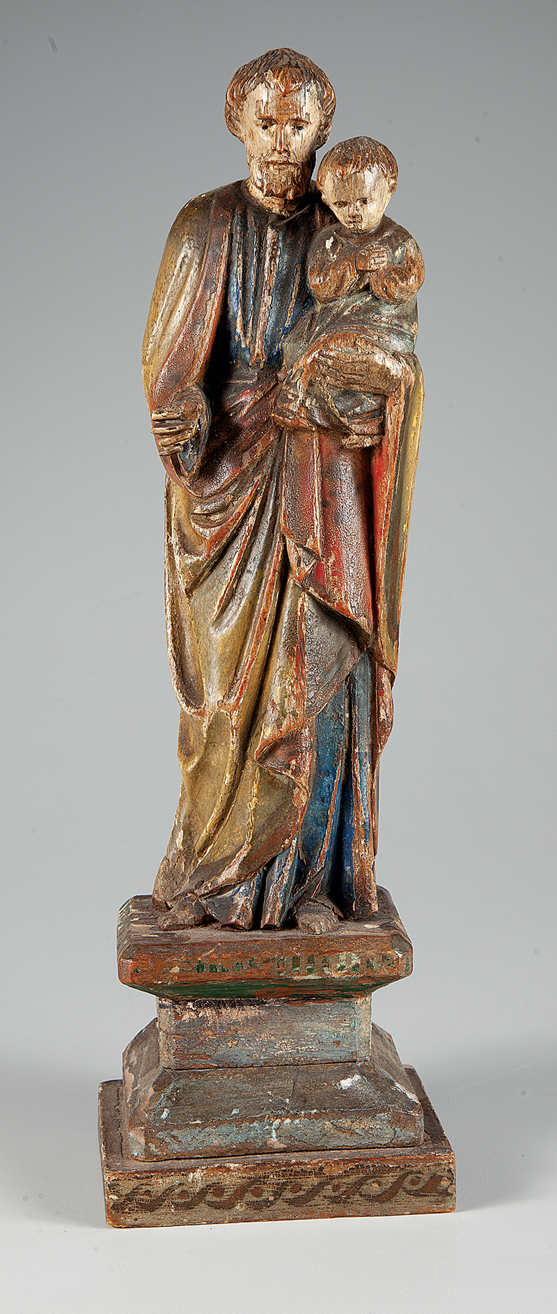 São José com Menino Jesus esculpido em madeira policromada medindo 42 cm. com a base ` Portugal ` Séc. XIX.