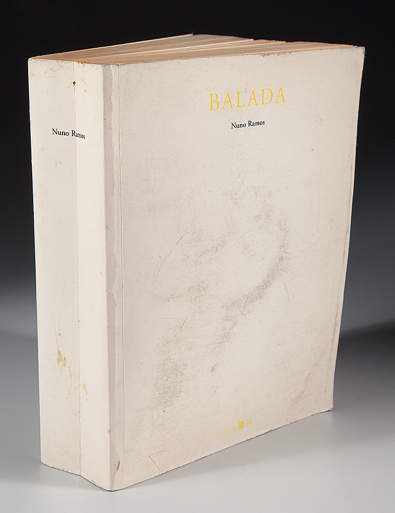 NUNO RAMOS - “Balada - 134 ” Livro, Pólvora e Bala - Assinado - 1995 - 23,5 x 17,5 x 5,5 cm.Livro de 896 páginas atravessado por uma bala de revólver, que se aloja ali dentro à altura da página 575 - Editora 34.Livro contém paginas amareladas e com manchas.